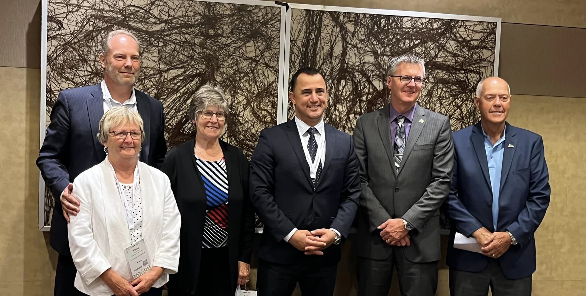 Image of a group photo at the AMO convention featuring MPP Holland, members from various municipalities, and Minister of Children, Community and Social Services, Michael Parsa. The photo captures a moment of collaboration and shared commitment to enhancing community services and social initiatives.