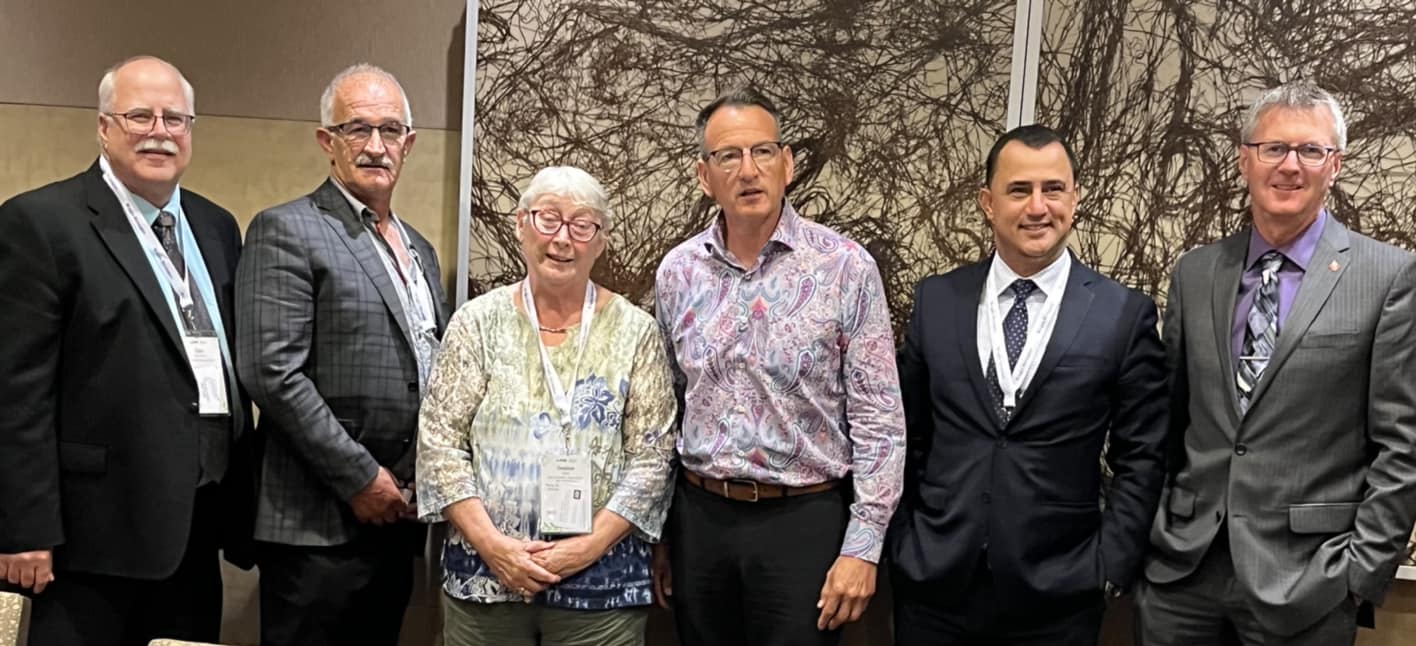 A photo at the AMO convention featuring MPP Holland, members from a municipality, and Minister of Northern Development, Greg Rickford. The image showcases a meaningful dialogue on northern development and strategic collaboration for the betterment of communities.